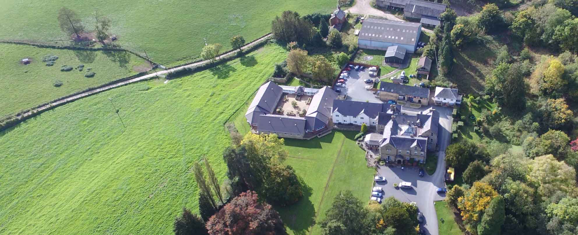 Aerial view of a countryside estate with buildings and green fields