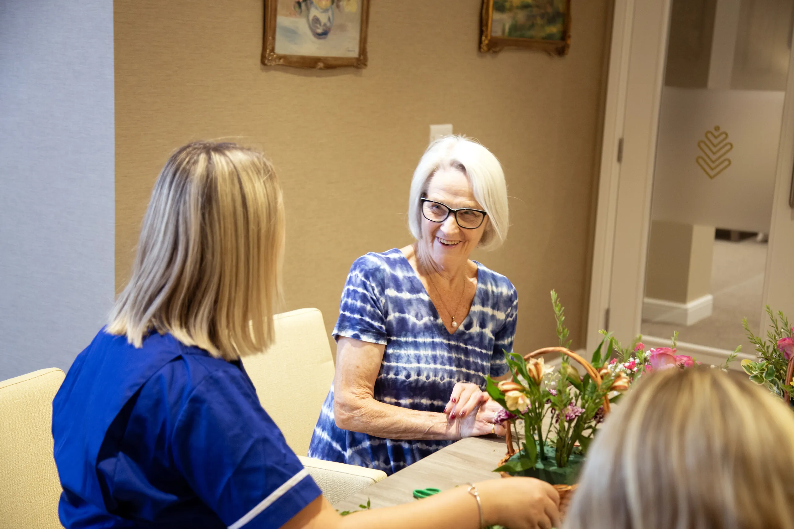 A resident arranging flowers with a member of the Colwall care team
