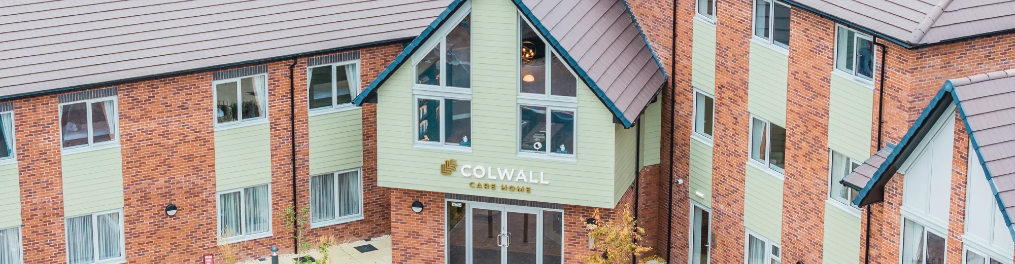 The entrance to Colwall Care Home, with its green-clad gable and Colwall Care Home sign above the front doors