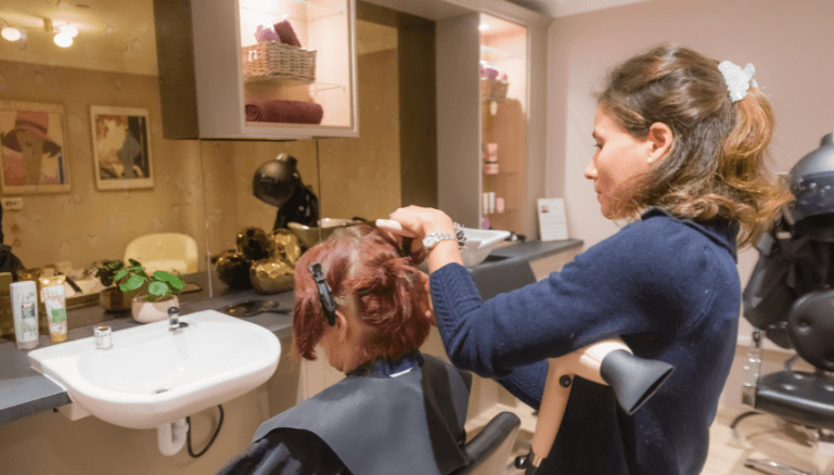 Cinema room with large comfortable chairs, a projector screen displaying the Warner Bros logo, and ambient lighting