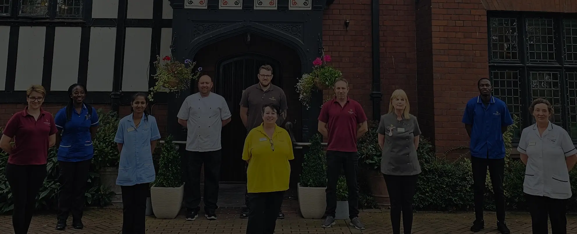 Various staff members in uniforms stand together