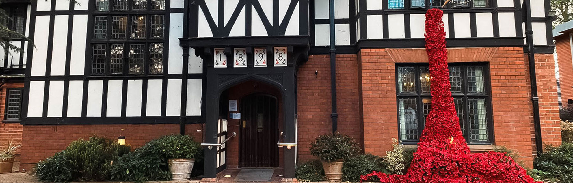 Tudor-style black and white building with poppies draped down it.