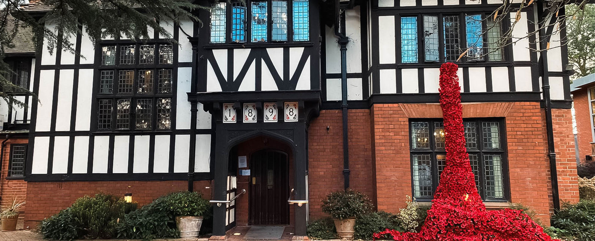 Tudor-style black and white building with poppies draped down it