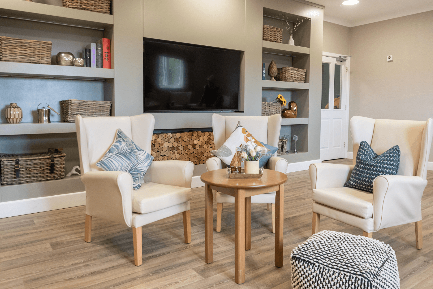 A cosy living room setting with two light grey sofas adorned with various patterned cushions