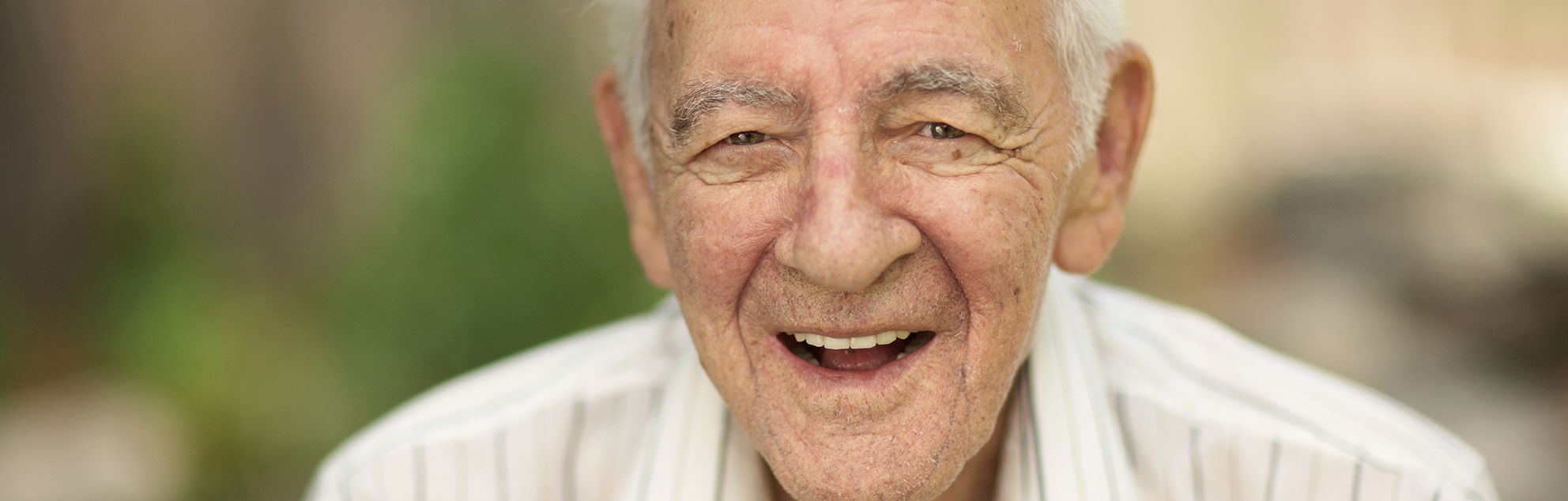 Close-up of an elderly man's face, who is smiling