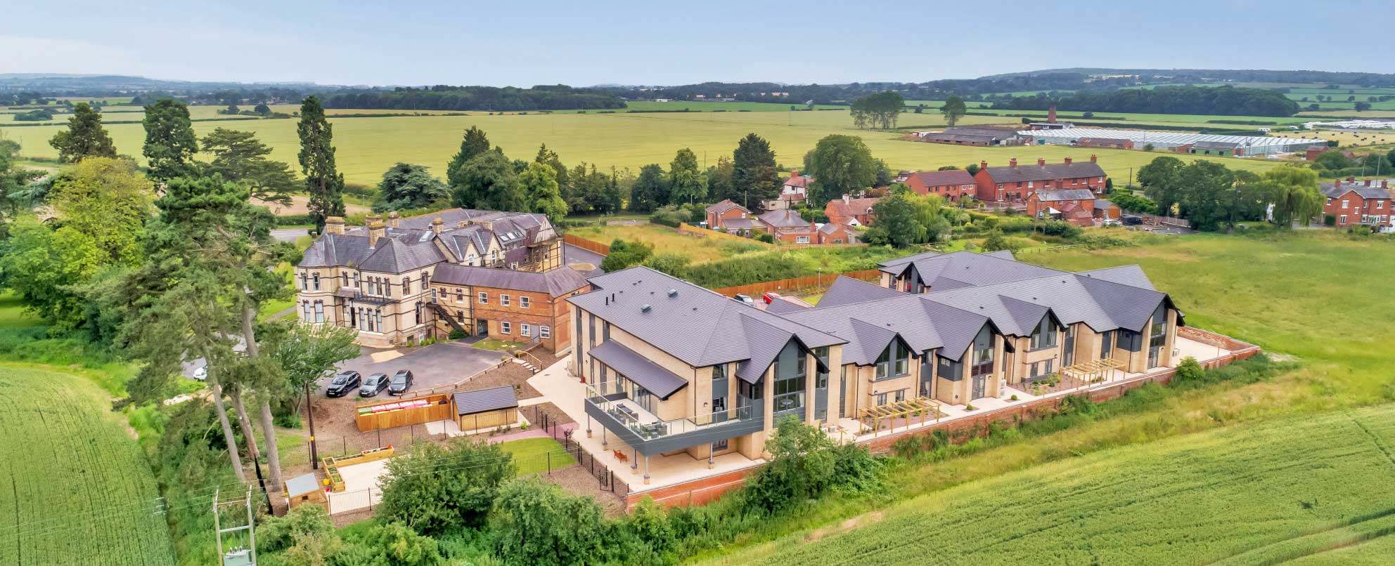 An ariel view of buildings in a rural setting with expansive green fields in the background