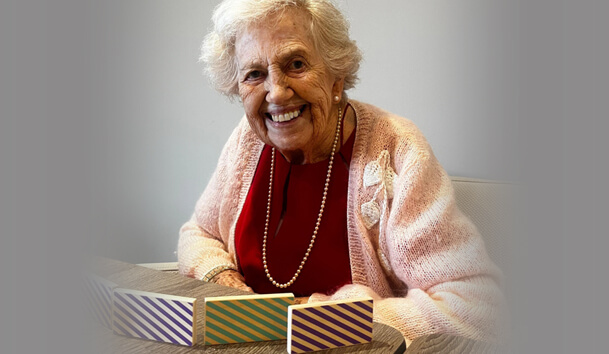 Elderly lady smiles as she plays a board game