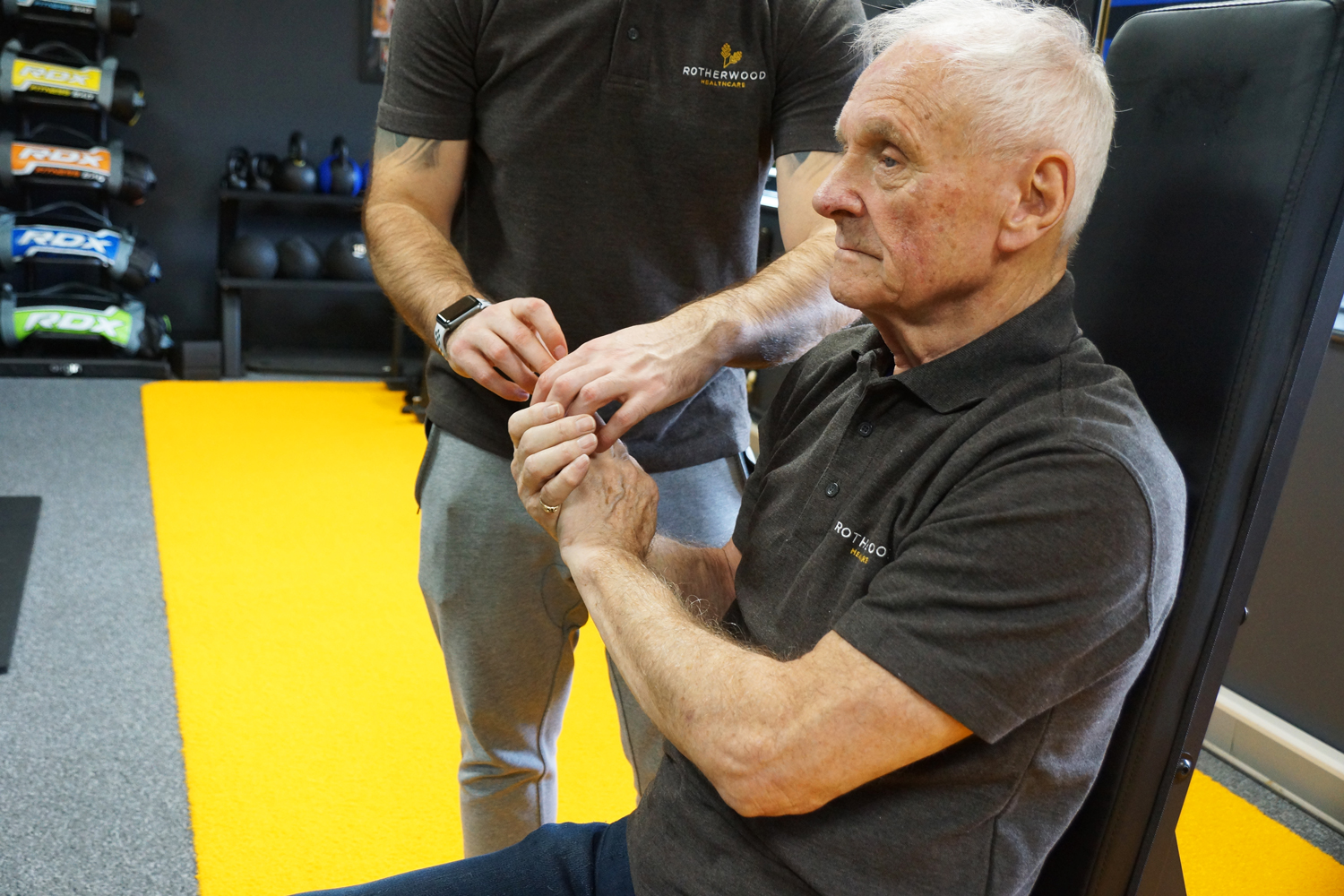Instructor leading elderly man doing isometric training
