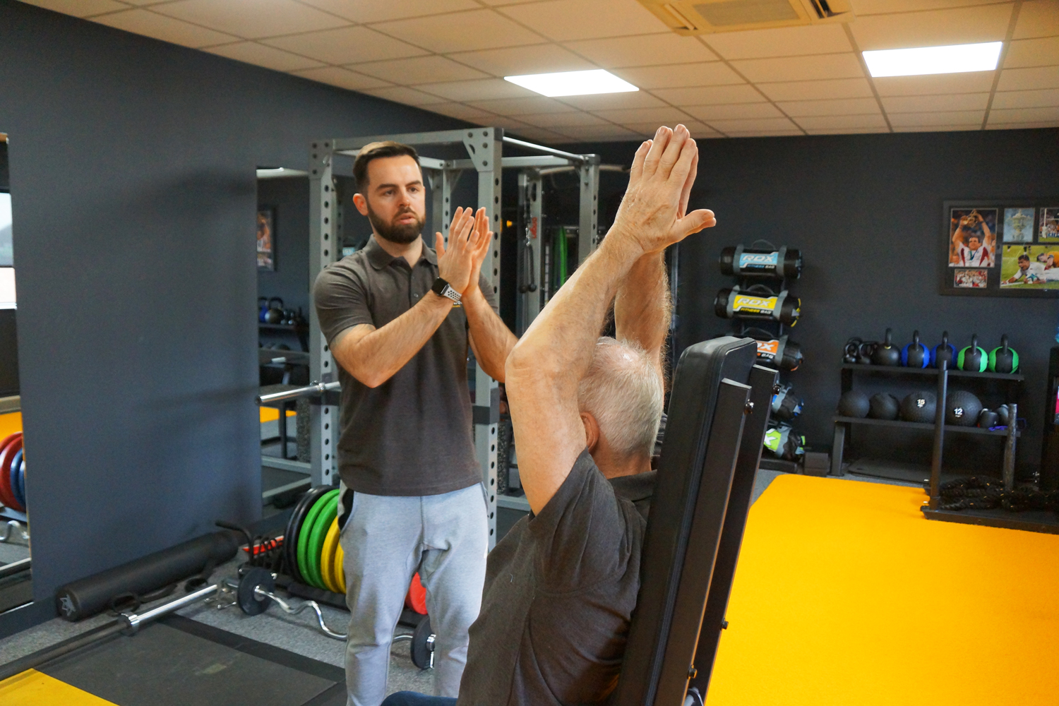 Instructor leading elderly man doing isometric training