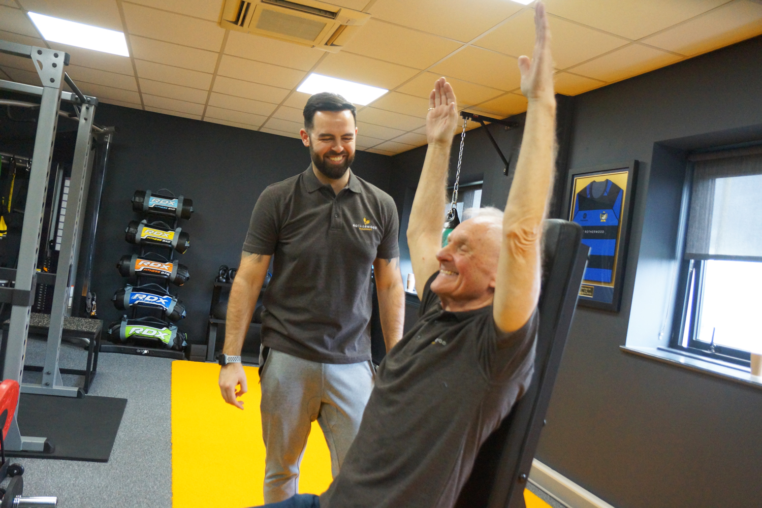 Instructor leading elderly man doing isometric training