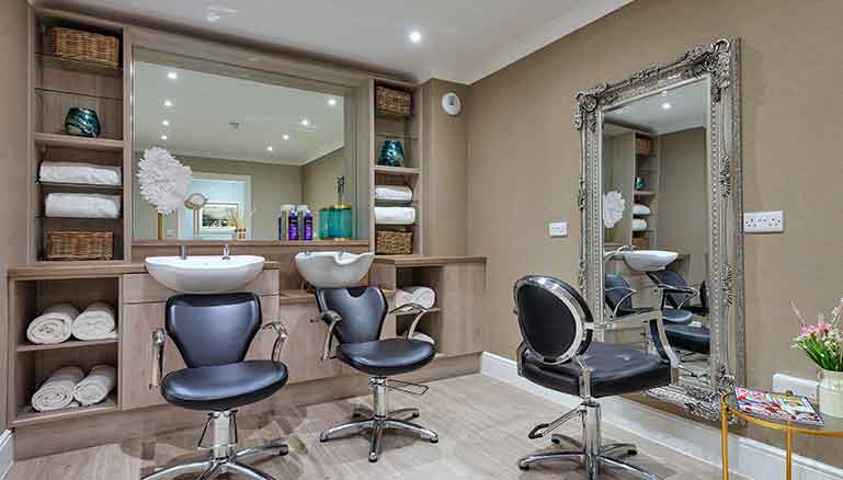 Modern, well-stocked and tidied hair salon with styling chairs and a hair washing sink