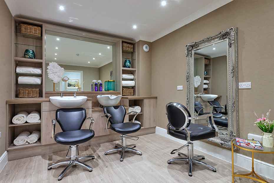 Modern, well-stocked and tidied hair salon with styling chairs and a hair washing sink