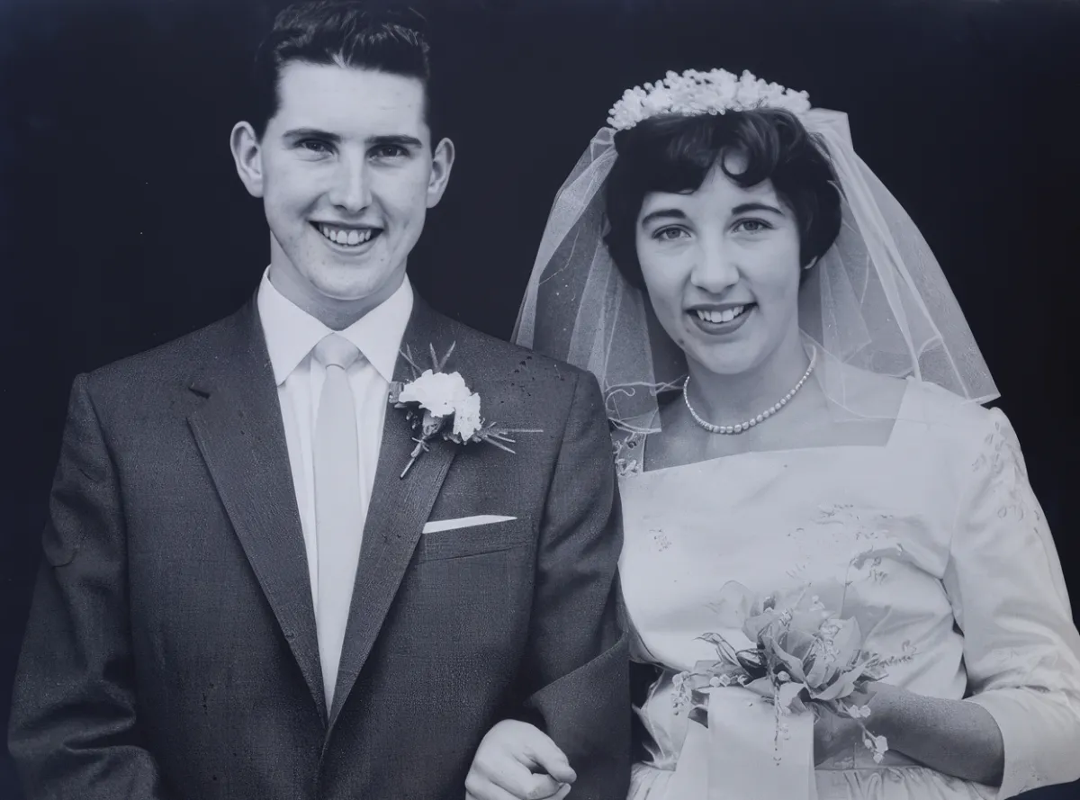 Dennis and Carole’s black and white wedding photograph, with Dennis in a suit and carnation buttonhole and Carole in a veil holding a bouquet